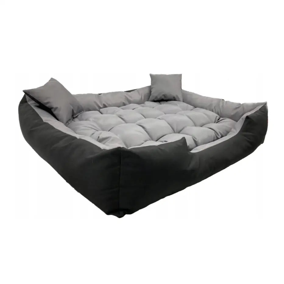 Hundeseng 115x95 stor, quiltet og vanntett, sett fra skrå vinkel med svarte kanter, lys grå pute og to små puter.