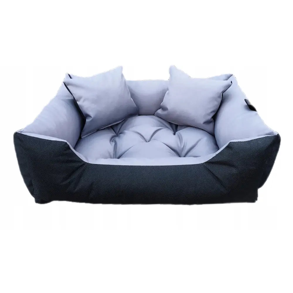 Hundeseng Liggeplass 95x75 i lysegrått stoff med polstrede kanter og to pynteputer, frontvisning mot hvit bakgrunn.