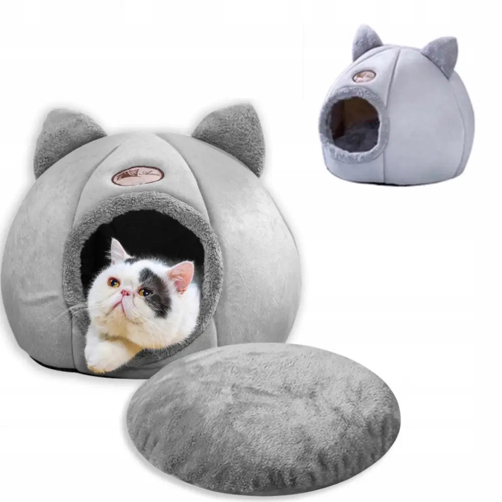 Husformet seng for katt og hund med grå innsats, sett forfra med ører og katt som hviler inni på avtakbar pute.
