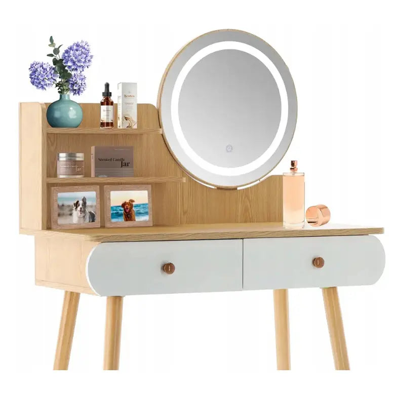 Hvit sminkebord i tre med LED-speil, to skuffer, små hyller og dekorative elementer som blomster og parfyme.