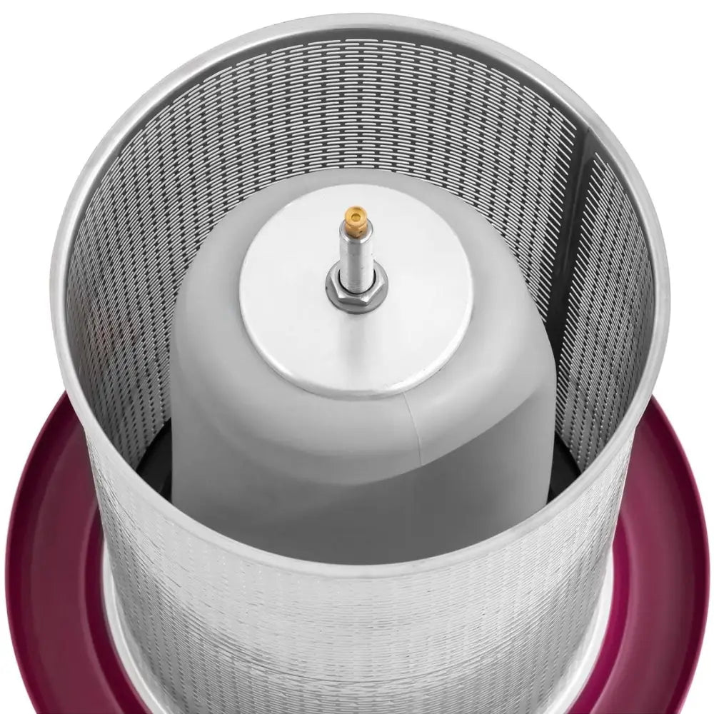 Hydrotrykkpresse for fruktjuice, toppvisning av perforert metallkurv med rød kant og sentral akse.