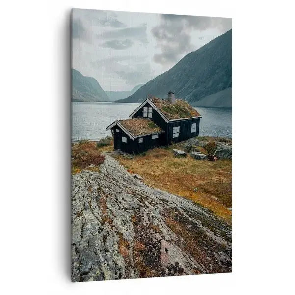 Lerretsbilde med tømmerhytte og torvtak ved innsjø, omgitt av fjell, sett fra skrå vinkel.