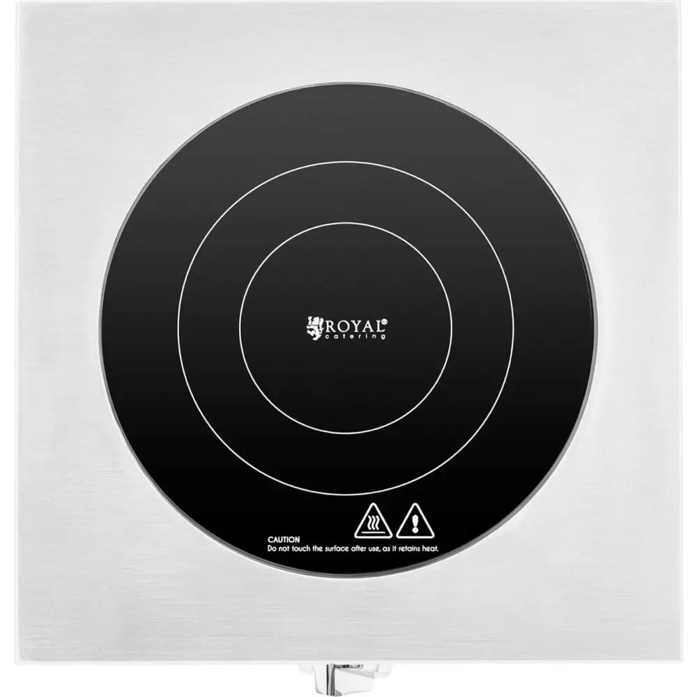 Induksjonskoketopp med svart glassoverflate, sirkulære markeringer og advarselssymboler sett ovenfra.