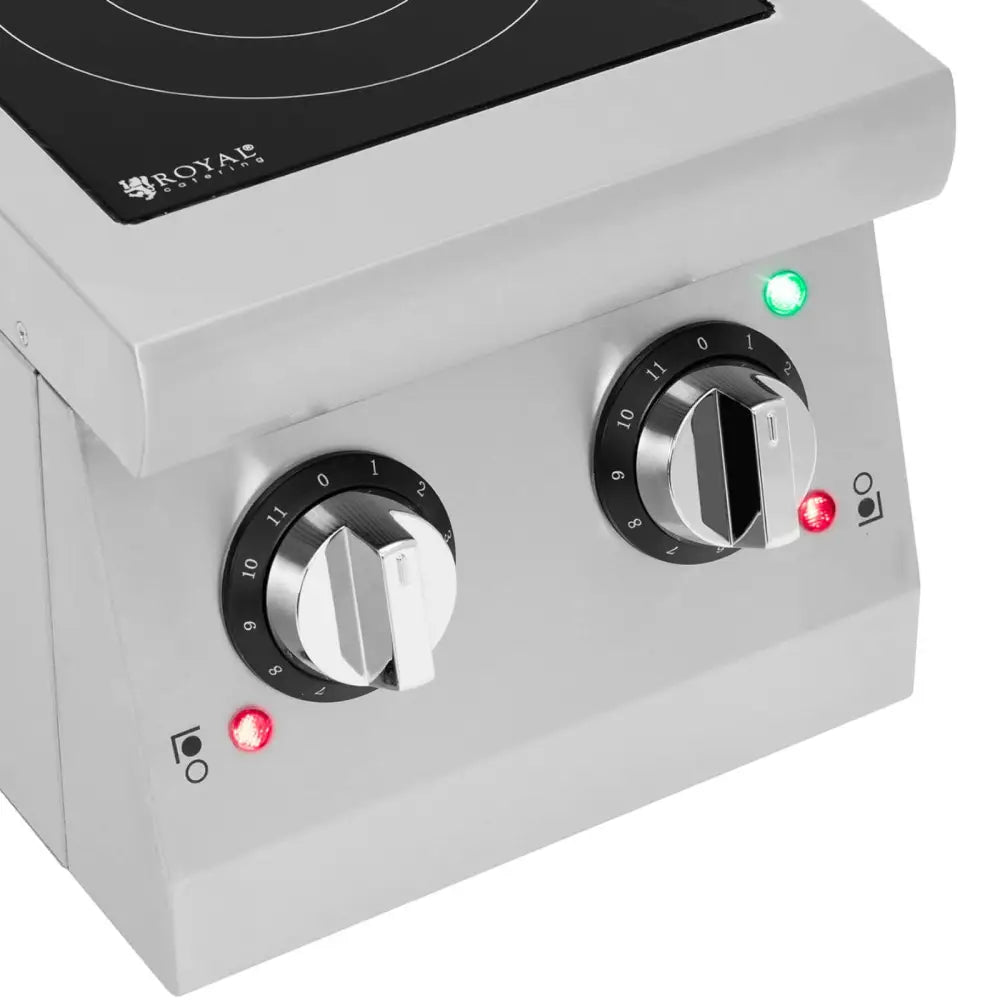 Induksjonstopp, detaljfokus på to rustfrie kontrollbrytere med svarte detaljer og indikatorlys på sølvfarget panel.