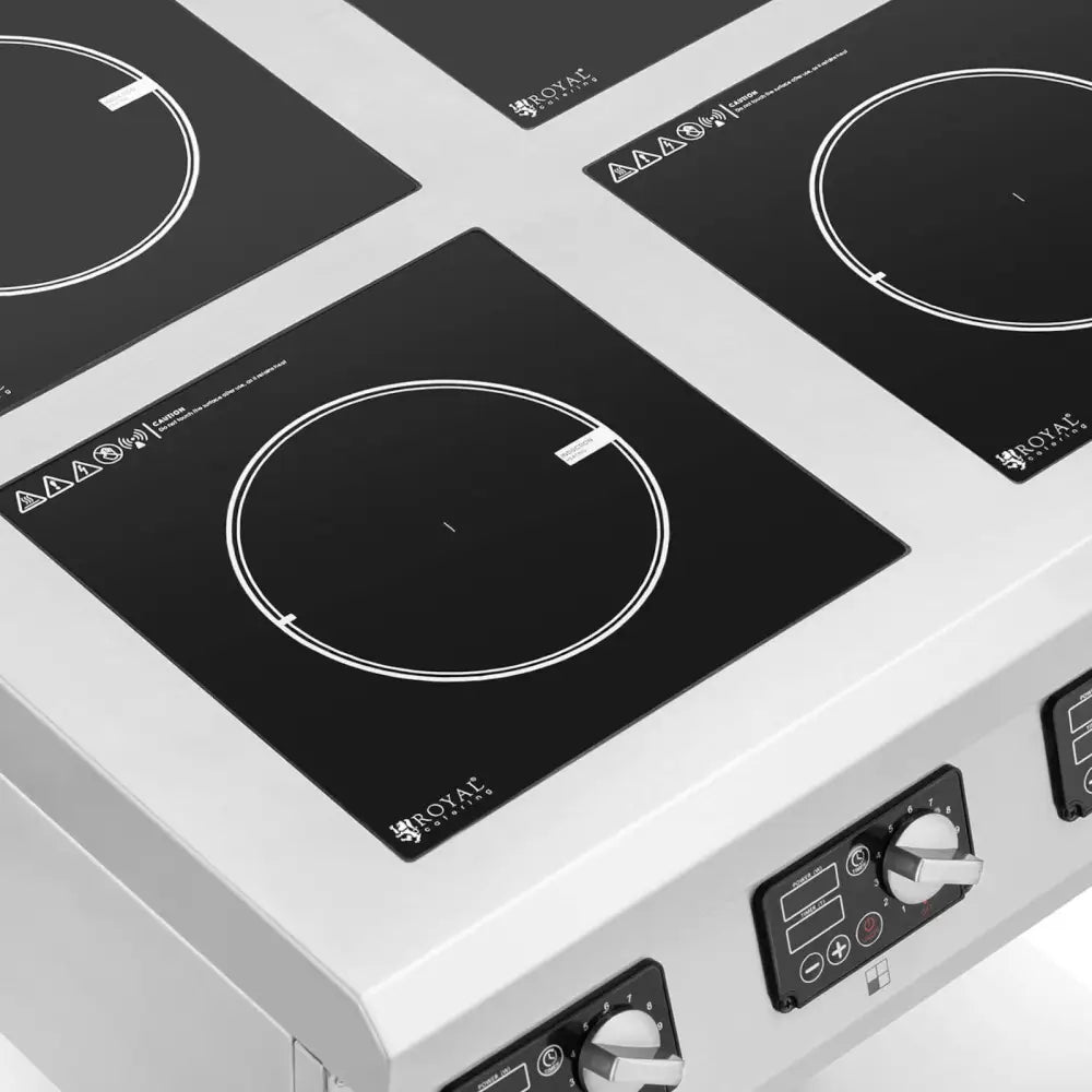 Induksjonstopp med fire brennere, sett skrått ovenfra, viser knotter og digitale skjermer i front.