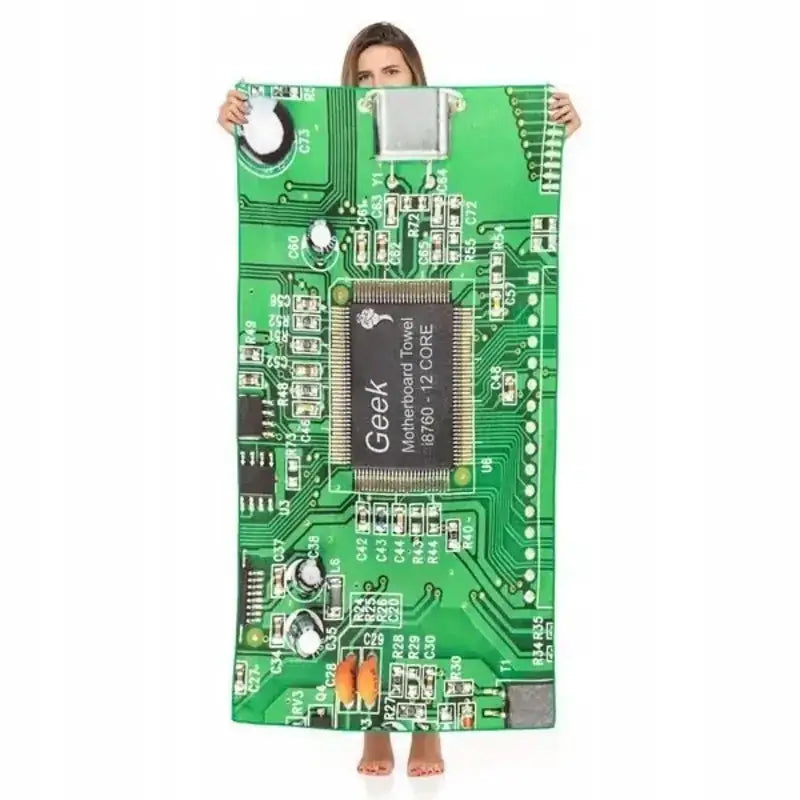 Informatikk badehåndkle med grønt kretskortdesign, holdt opp foran en person, detaljerte komponenter synlige.