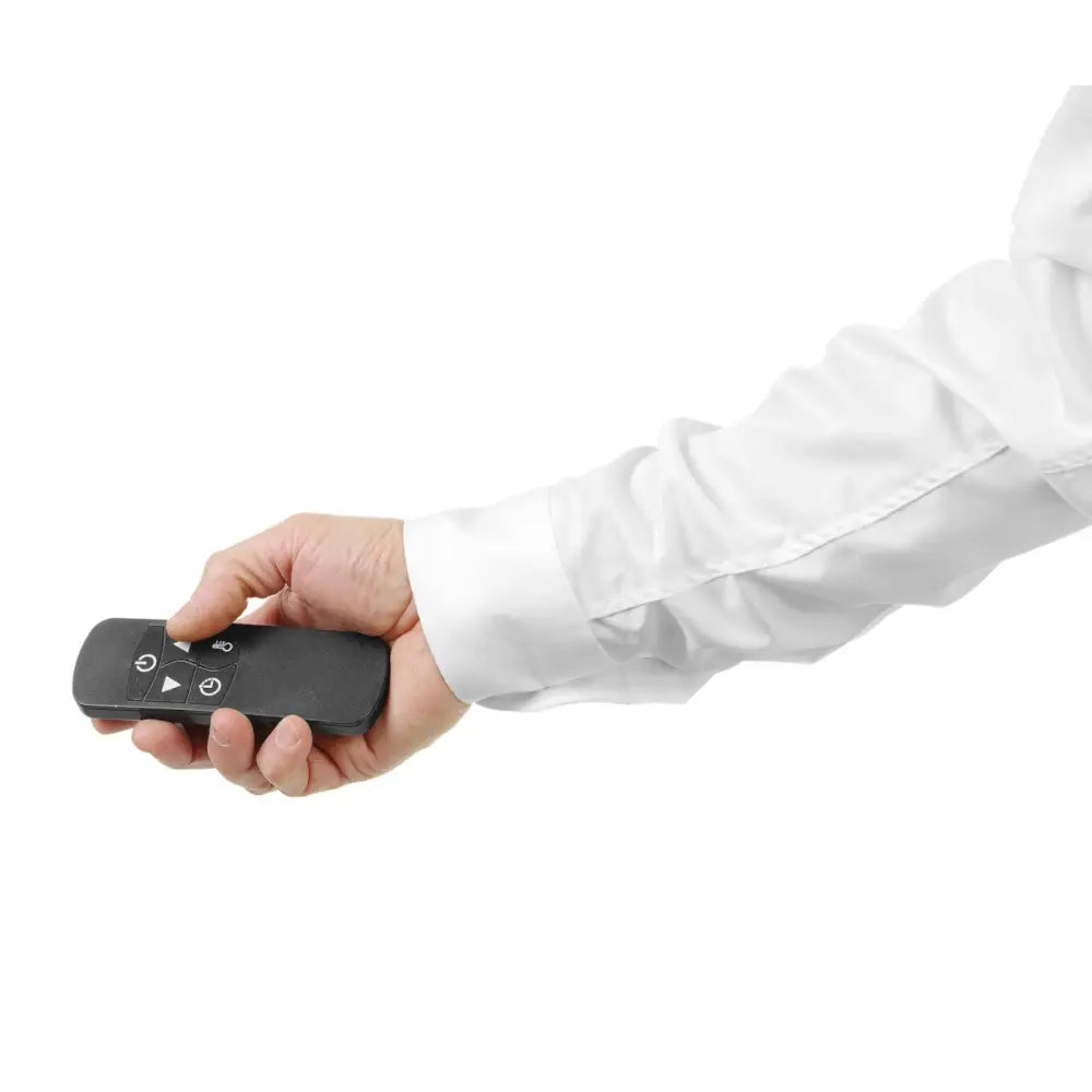 Infrarød varmelampe Tornado fjernkontroll, holdt i hånd med hvit skjorte, viser store funksjonsknapper.