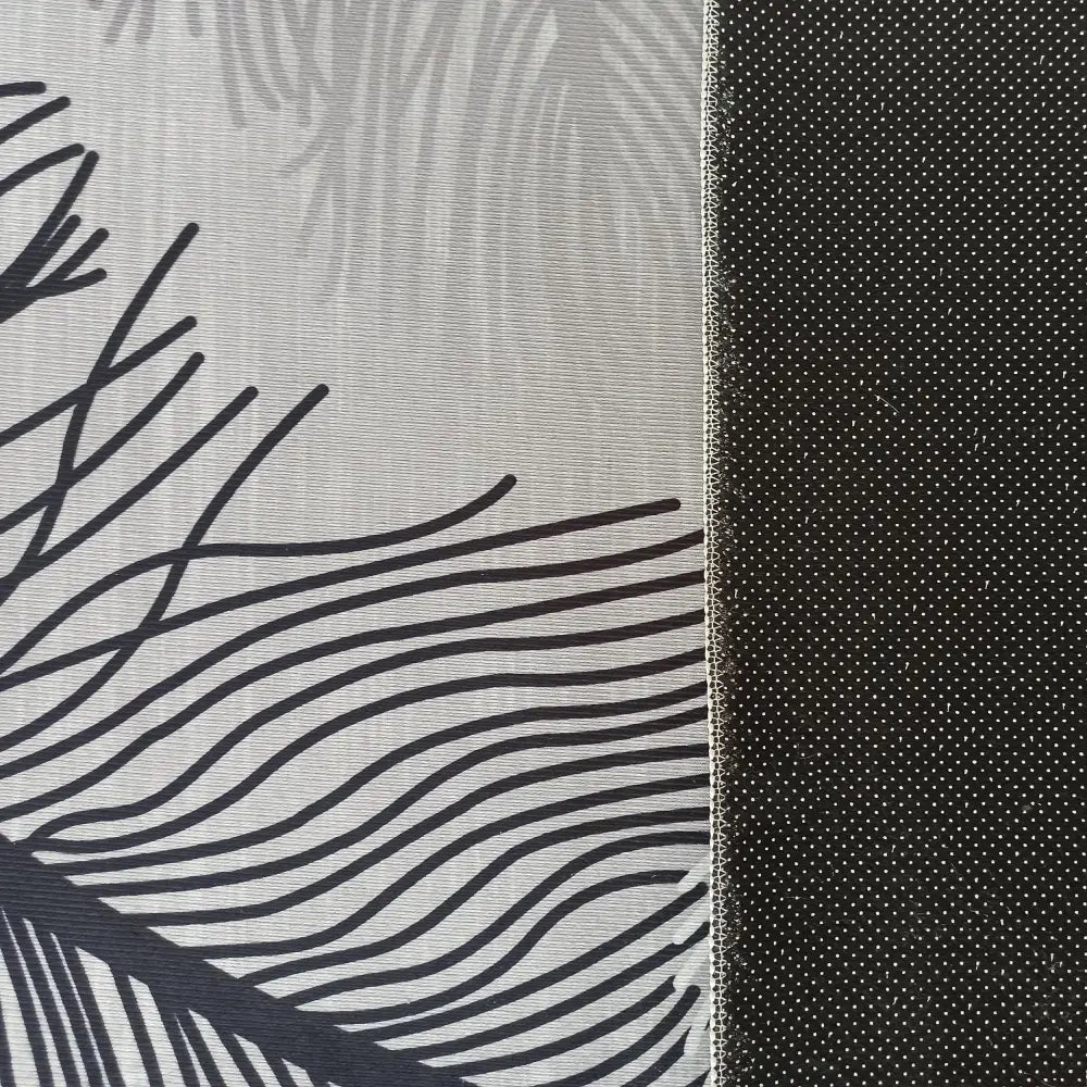 Interiør Tepen, detaljert nærbilde av grått tekstil med svart fjærmønster og svart stoff med hvite prikker, synlig søm.