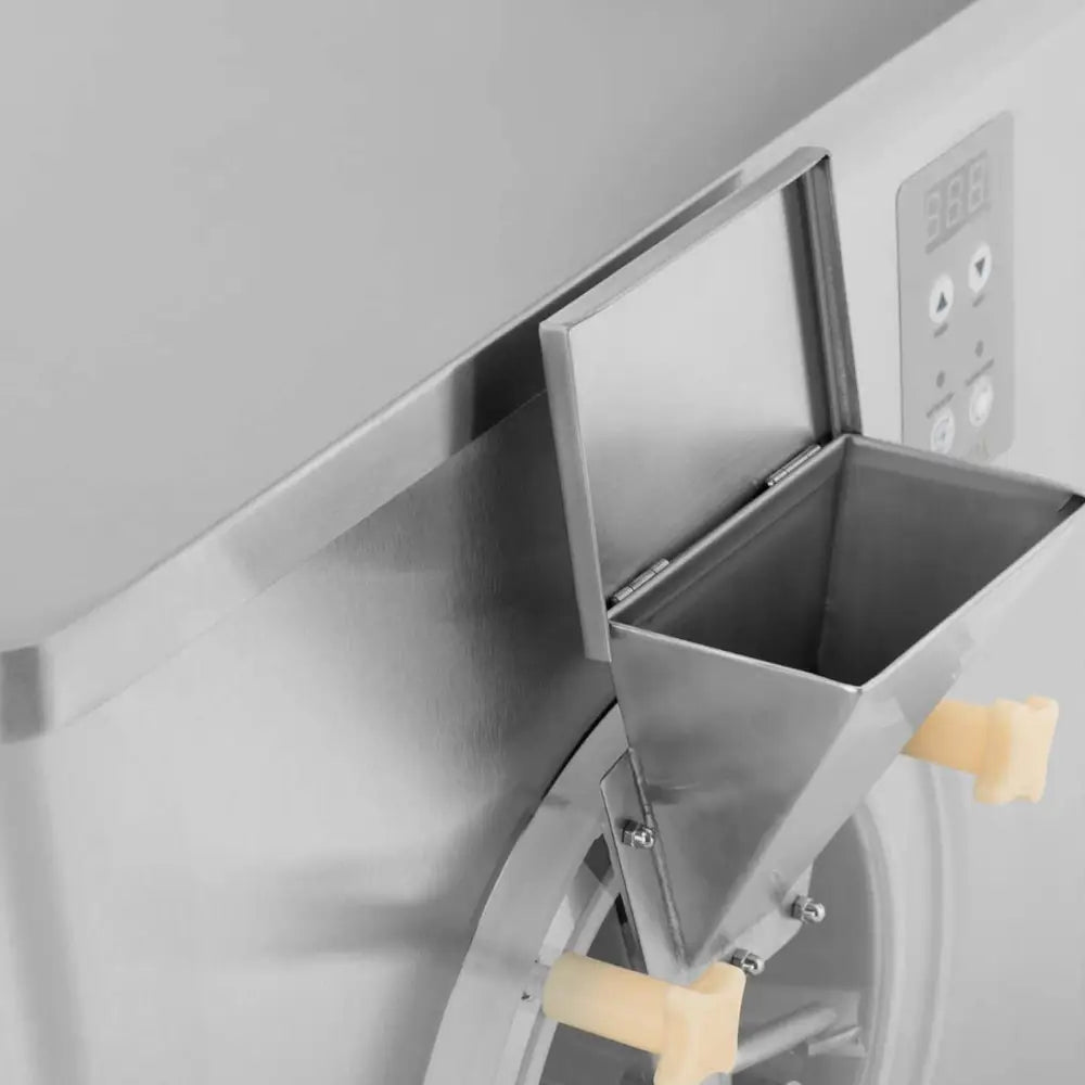 Iskrem- og sorbettmaskin, nærbilde av åpen innmatingsluke i stål med lysegule håndtak og kontrollpanel.