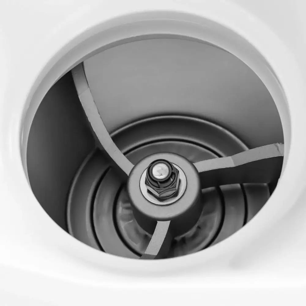 Iskremmaskin, nærbilde ovenfra som viser de tre roterende knivene i rund metallbeholder med hvit kant.