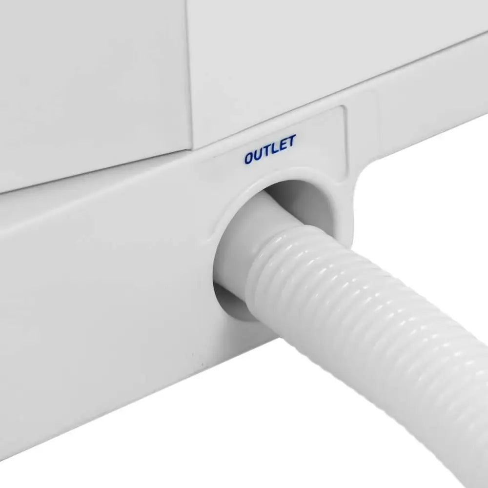 Iskremmaskin, detaljvisning av hvitt rillet avløpsrør koblet til blått merket "OUTLET"-uttak på plastenhet.