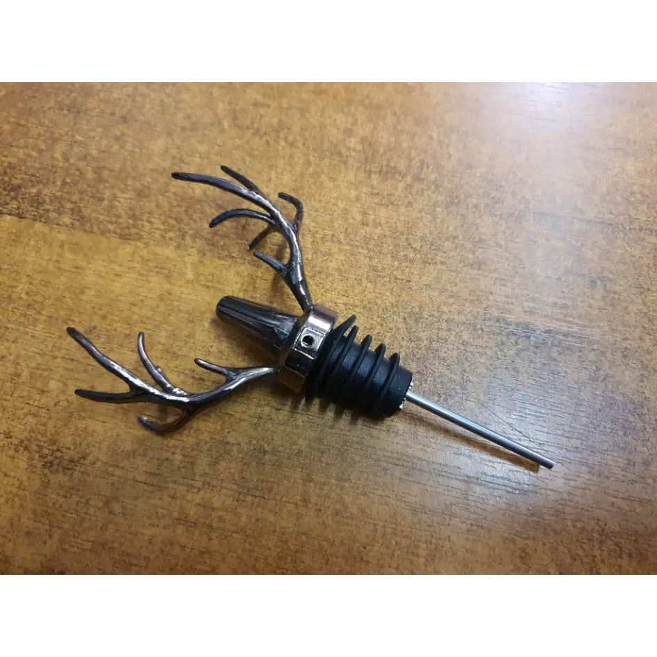 Jägermeister tappeapparat med hjortehorn, sidevisning av metallhelletut med sorte gummiriller og hornformede håndtak.