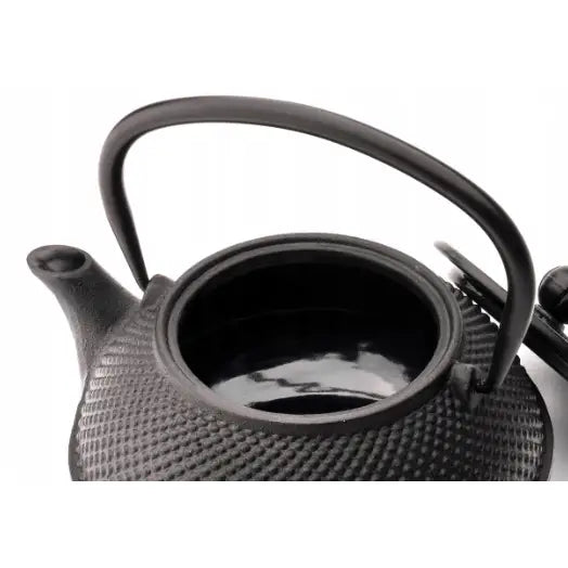 Jang tekanne i svart støpejern, sett ovenfra med åpent lokk, synlig riflet utside og blank innside.