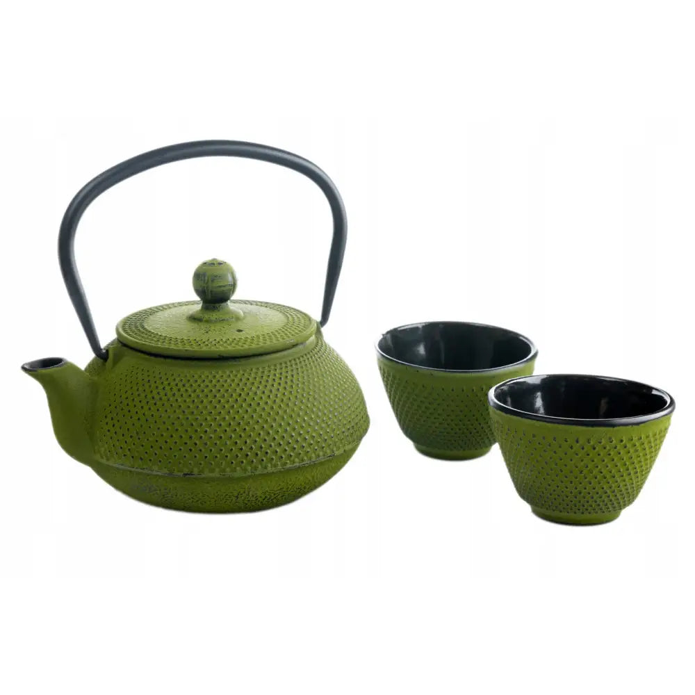Jernkanne med grønn strukturert overflate, to kopper med sort innside og tesil, skrå visning.