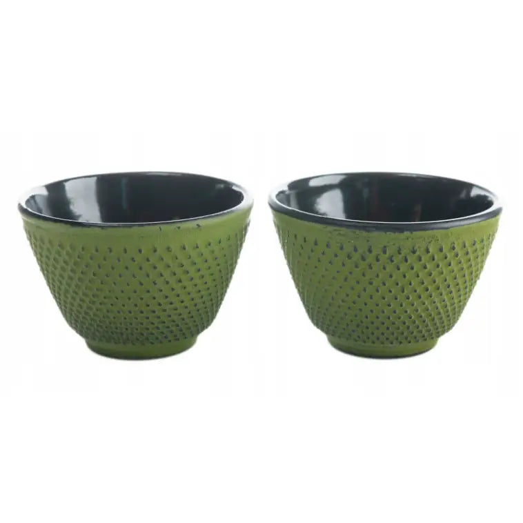 To grønne keramikkopper med sort innside og prikket overflate, presentert forfra mot nøytral bakgrunn.