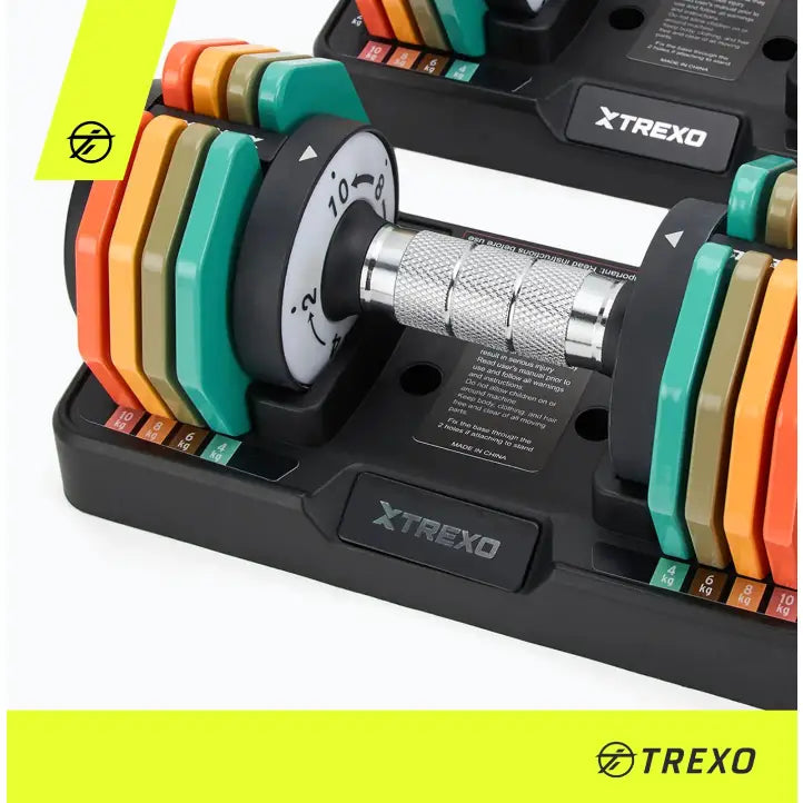 Justerbar manual fra Trexo, skråvisning med fargerike vektskiver, synlig vektindikator og XTREXO-logo på basen.