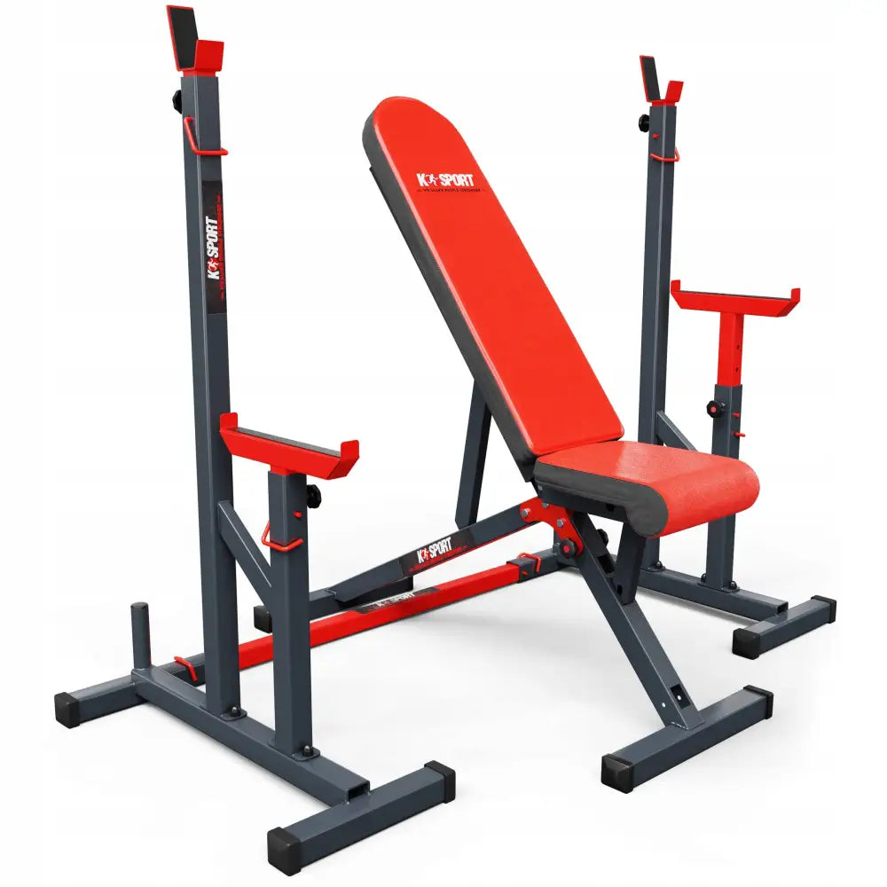 Treningsbenk med justerbar rygg og sete i rødt kunstskinn, mørk grå ramme og røde stativdetaljer, frontvinkel.