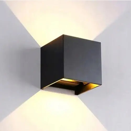 Justervbar vegglampe Tube Opp Ned LED i sort metall, sidevisning med dobbelt V-formet lysspredning på veggen.