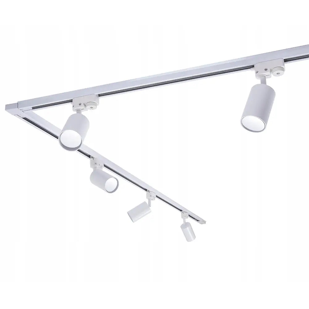 Kabelskinnesett med hvite, sylinderformede spotlys på metallskinner, sett skrått nedenfra med justerbare hoder.