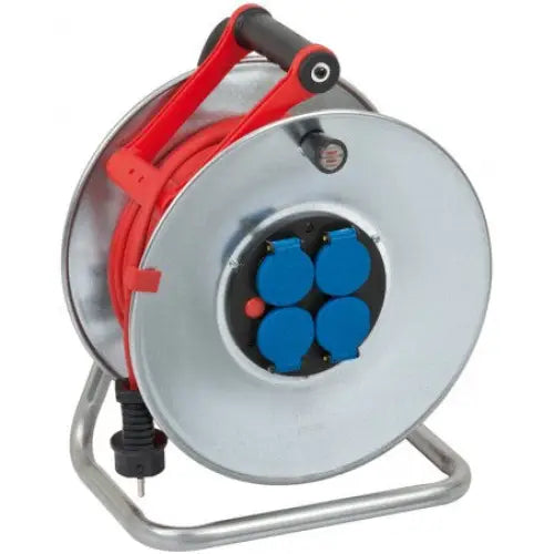 Kabeltrommel Garant S, metallhus med fire blå uttak, rød kabel og sort håndtak på sølvstativ.