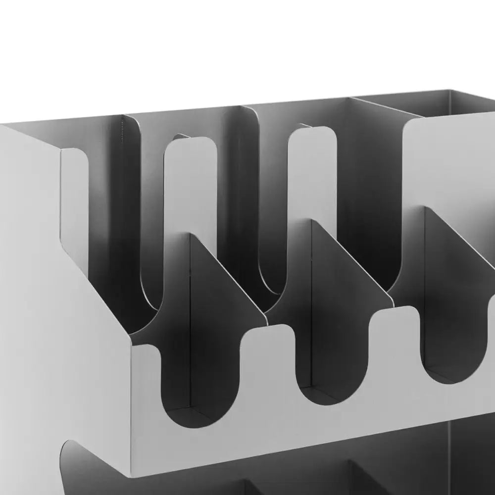 Kaffekopporganiser i sølvfarget metall, nærbilde fra skrå vinkel som viser bølgete utskjæringer og 11 rom.