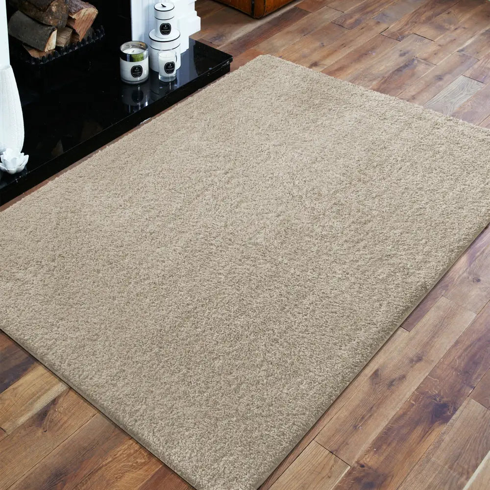 Beige Kamel-teppe 200 x 290 cm med kort lugg, skråvinklet på tregulv ved peis.