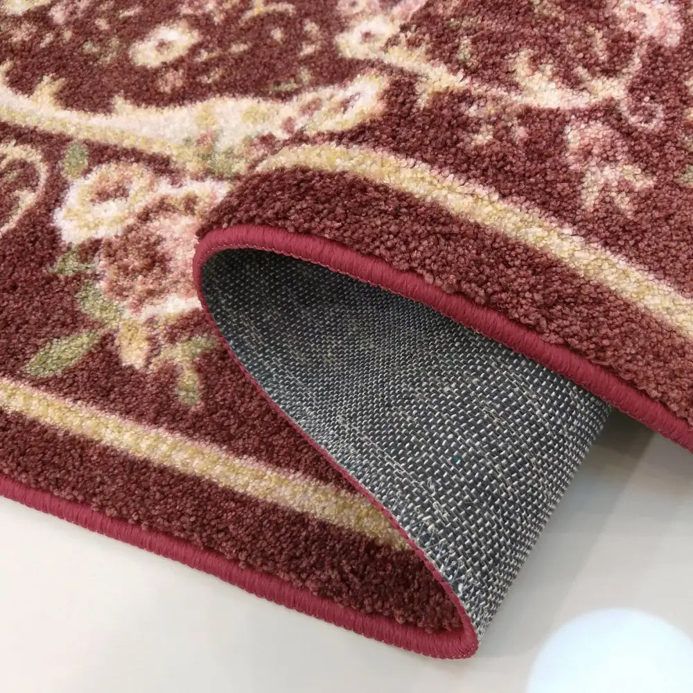 Kasablanka Red Tepe, nærbilde som viser burgunderrødt blomsterdesign, teppets tykkelse og grå bakside.