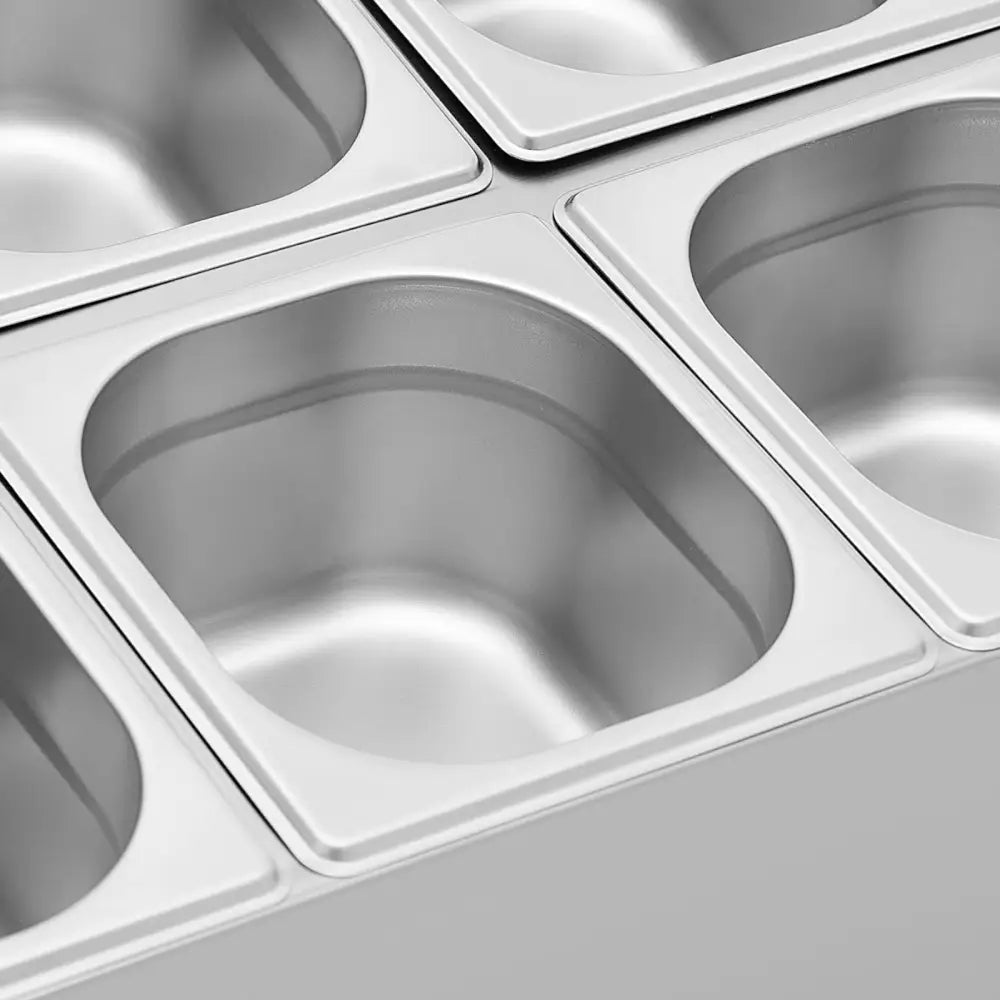 Katalogstativ for GN 1/6 beholdere, fire stålkantiner sett ovenfra med glatte, avrundede hjørner.