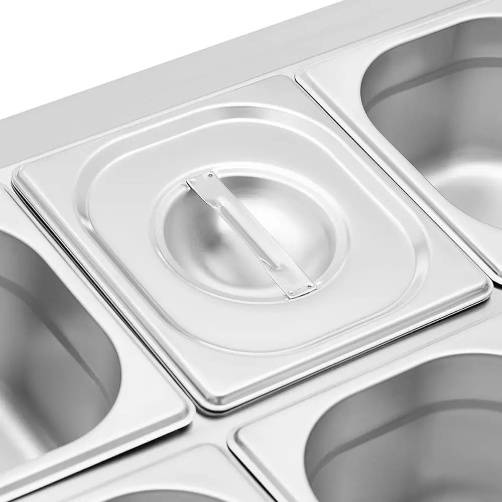 Katalogstativ for GN 1/6 beholdere, skrå oversiktsvinkel med én lukket beholder og synlige avrundede ståldetaljer.