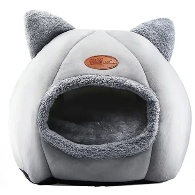 Kattehus XL Myk Seng Hundehytte, frontbilde av lys grå plysjhule med ører og mørk kant rundt inngangen.
