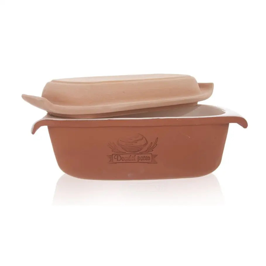 Keramisk brødform med lokk, sidevisning hvor det løse lokket og dekorativ logo på langsiden er synlig.