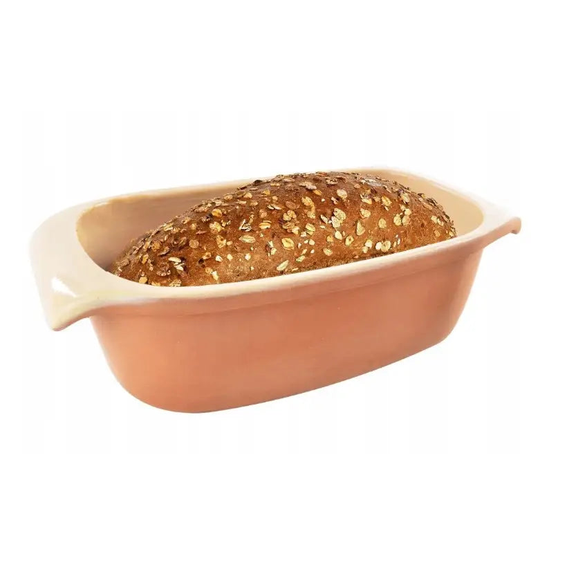 Keramisk brødform med lokk, skrå sidevisning med ferskt brød toppet med frø og korn i formen.