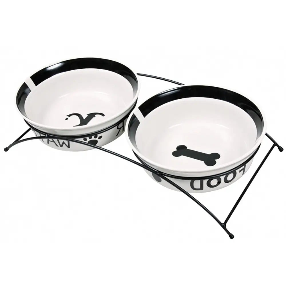 Keramisk skålsett for hund og katt fra Trixie, to hvite skåler med bein- og vannsprutmotiv i sort metallstativ.