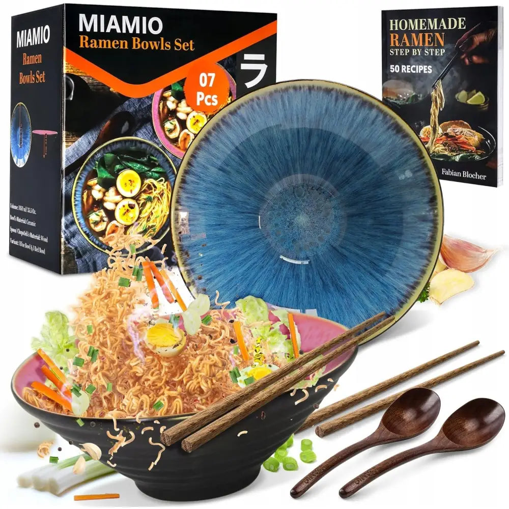 Keramiske ramen suppeskåler med blå innside, sorte utsider, spisepinner, treskjeer og oppskriftsbok.