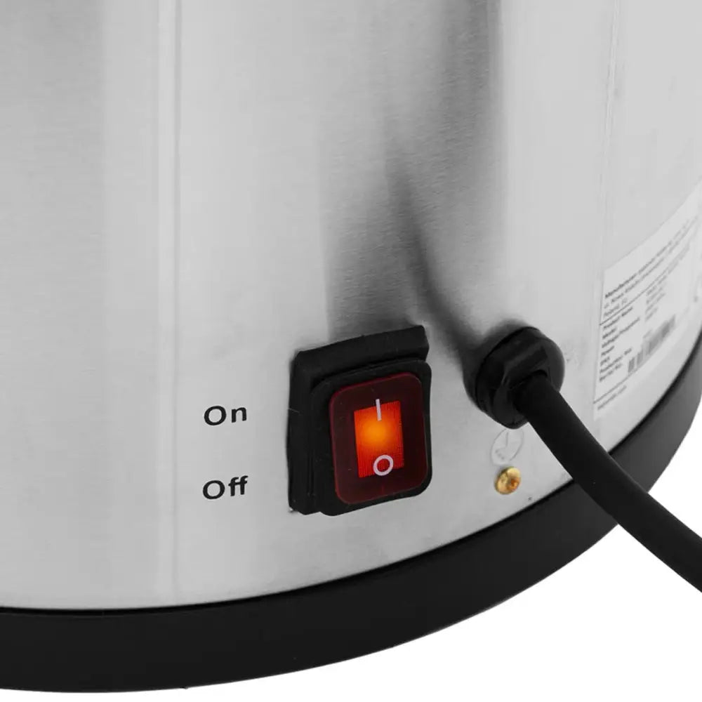 Kjele vannvarmer, detaljvisning av rødt av/på-bryterpanel med opplyst bryter og sort ledning mot ståloverflate.