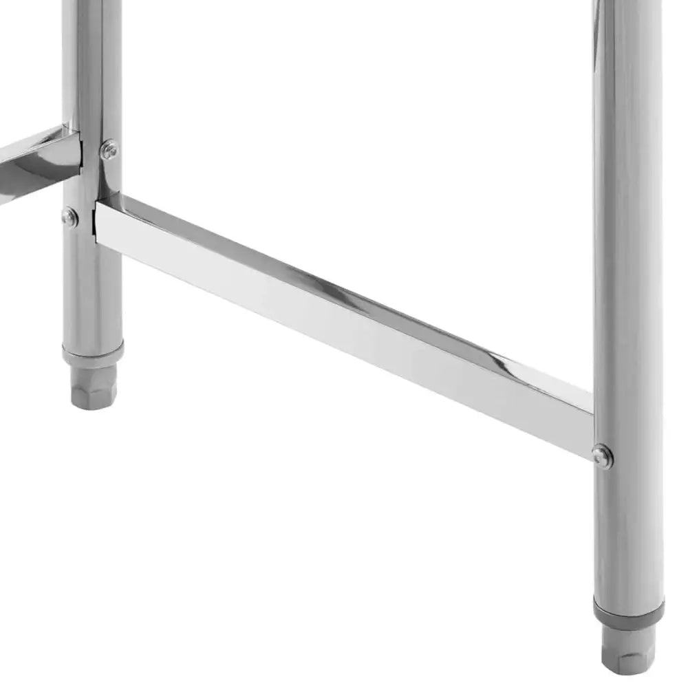 Kjøkkenbord i rustfritt stål, nærbilde av sylinderformede ben og blank støttebjelke mot hvit bakgrunn.