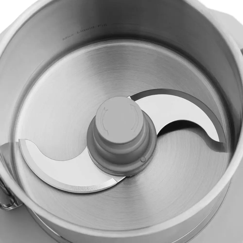 Kjøkkenhakker med dobbel metallkniv, sett ovenfra i rustfri stålbolle med blank overflate og skarpe blader.