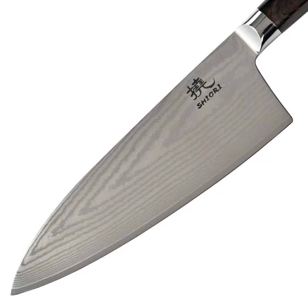 Kjøkkenkniv i japansk Damascus-stål, sidevisning med synlig damaskmønster og gravert logo nær håndtaket.