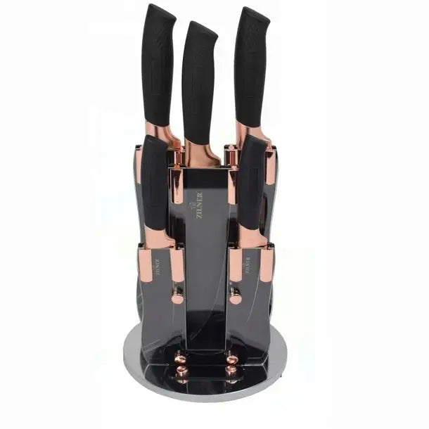 Kjøkkenknivsett i sort og rosegull, stående i roterende knivblokk med teksturerte håndtak og moderne design.