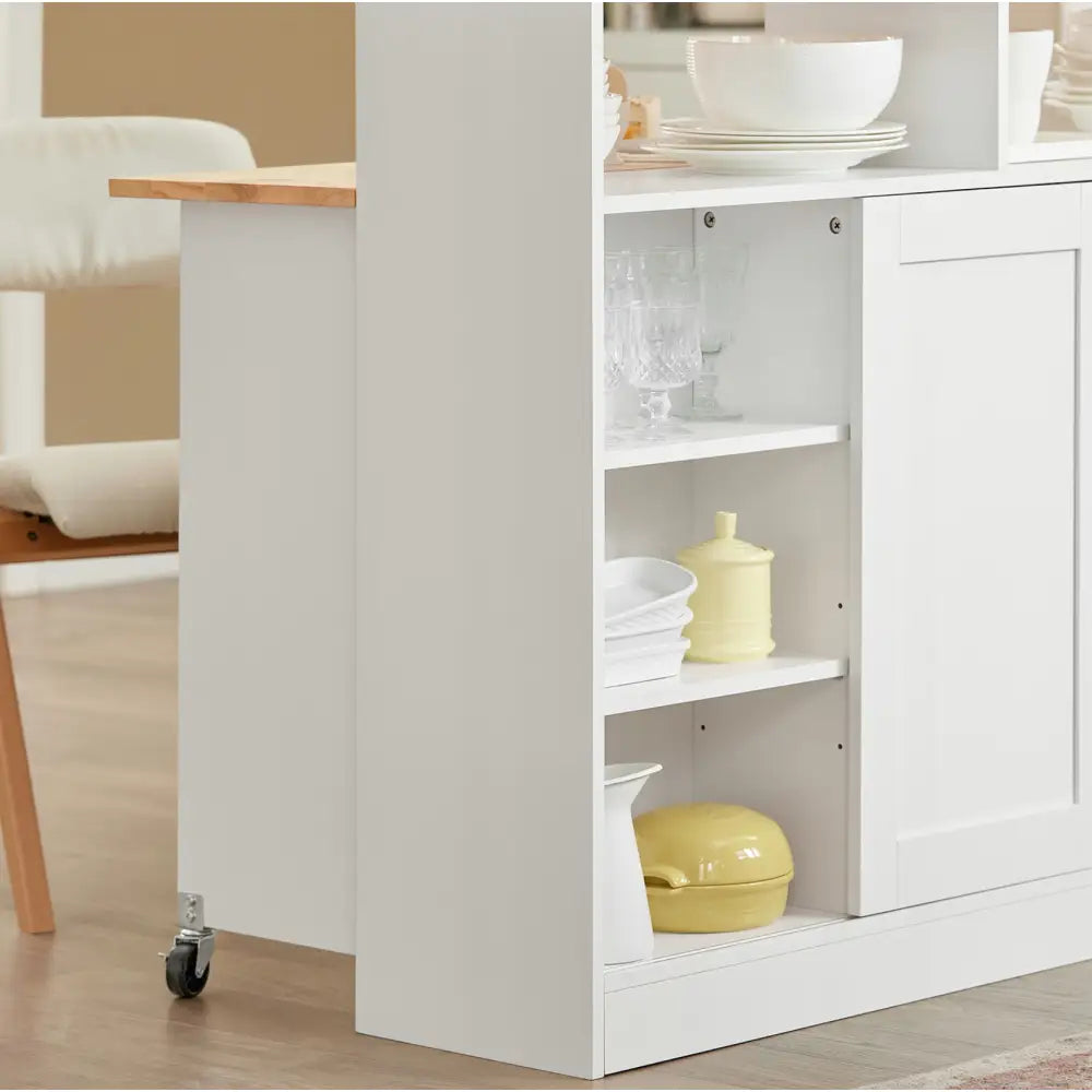 Kjøkkenøy med skap, sidevisning av åpne hyller fylt med servise, glass og gule keramikkbeholdere.