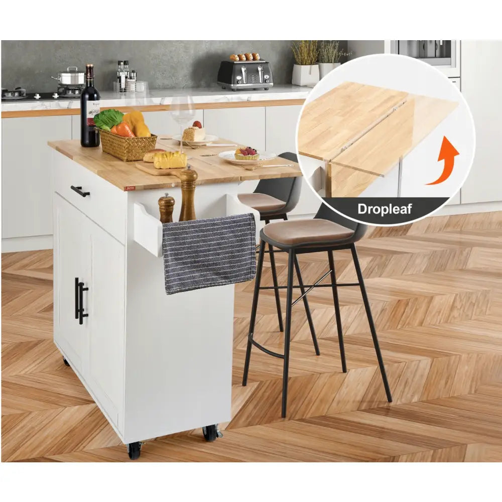 Kjøkkenøy på hjul, hvit modell med lys treplate, utsvingbar klaff og håndklehenger sett fra skrå vinkel.