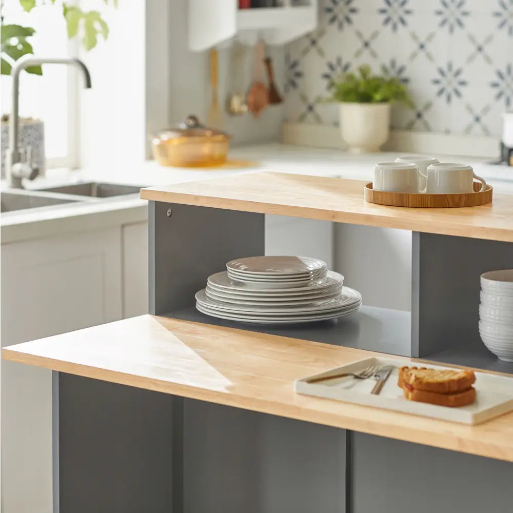 Kjøkkenøy med grå detaljer, åpne hyller fylt med hvite tallerkener og kopper, i lyst, moderne kjøkken.