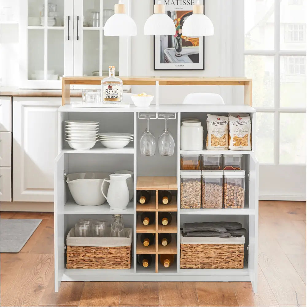 Kjøkkenøy med hvite åpne hyller, vinreol og servise, frontbilde i lyst kjøkken med oppbevaringsbokser.