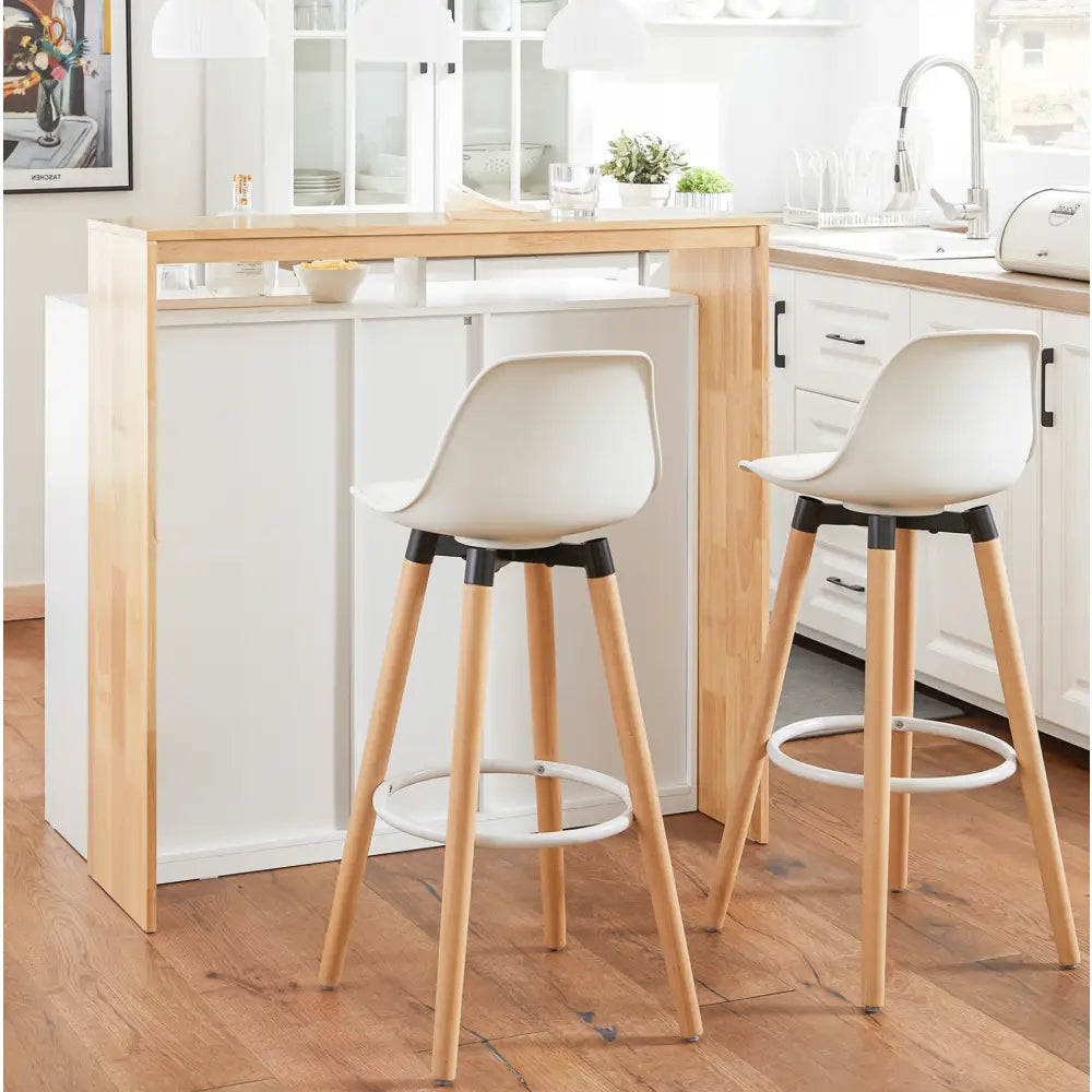 Moderne barkrakker med hvite seter og lyse treben, skrå vinkel ved kjøkkenøy med metallfotstøtte.