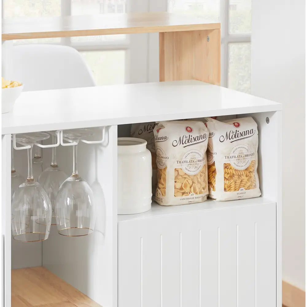 Kjøkkenøy med hvit oppbevaringshylle, vinglassholder med seks glass, keramikkrukke og to poser pasta, sidevisning.