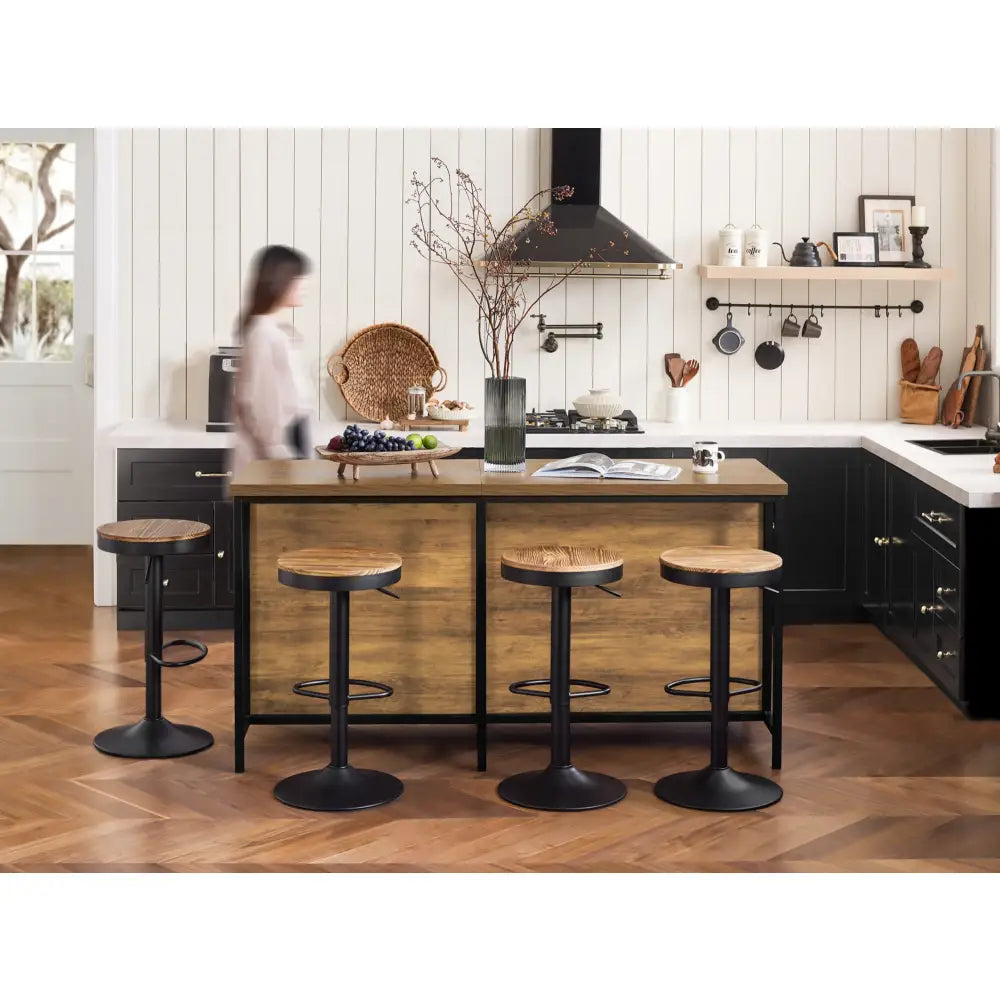 Kjøkkenøy spisebord med fire barkrakker i svart metall og mørkt tre, sett mot moderne kjøkken.