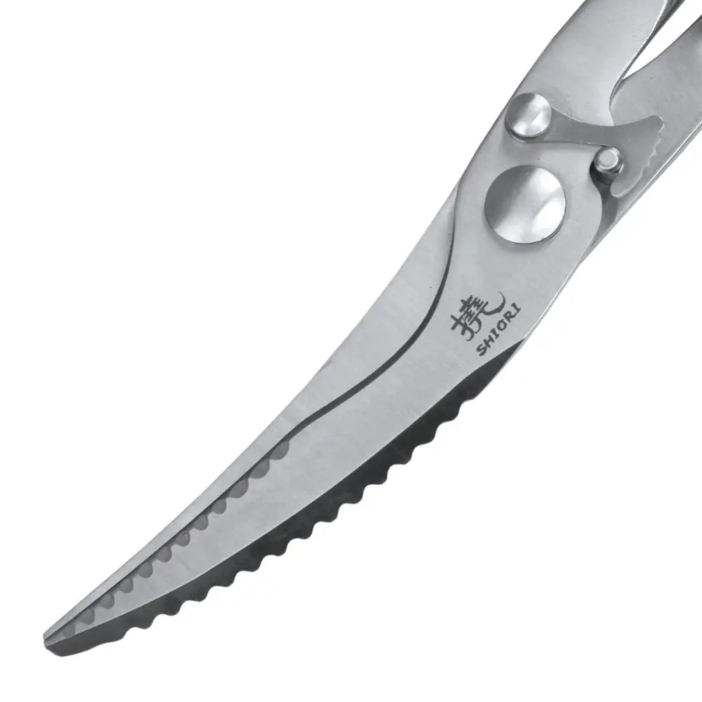 Kjøkkensaks i rustfritt stål, nærbilde av buet, sagtakket blad med japansk gravering og SHIORI-logo.