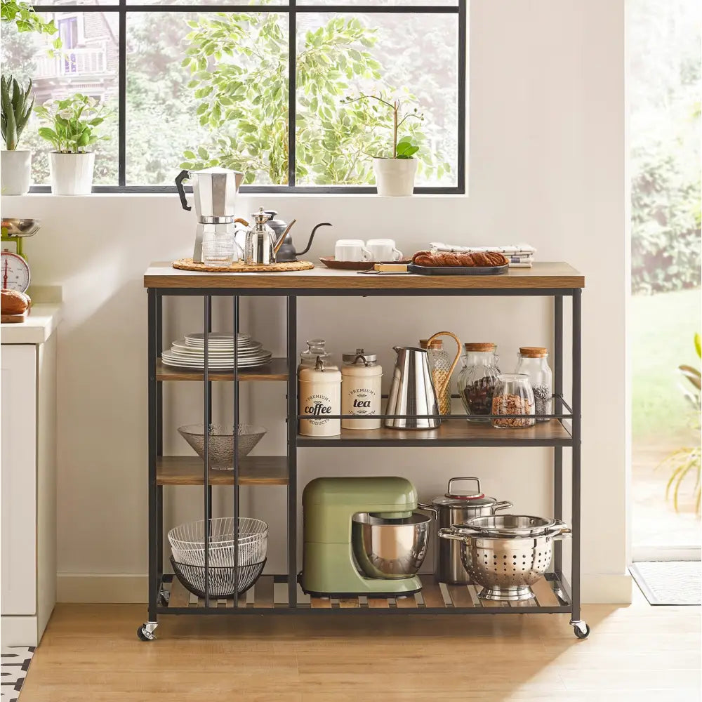Kjøkkentrolley i sort metall og tre, frontvisning med hyller fylt av kjøkkenutstyr og grønn kjøkkenmaskin.