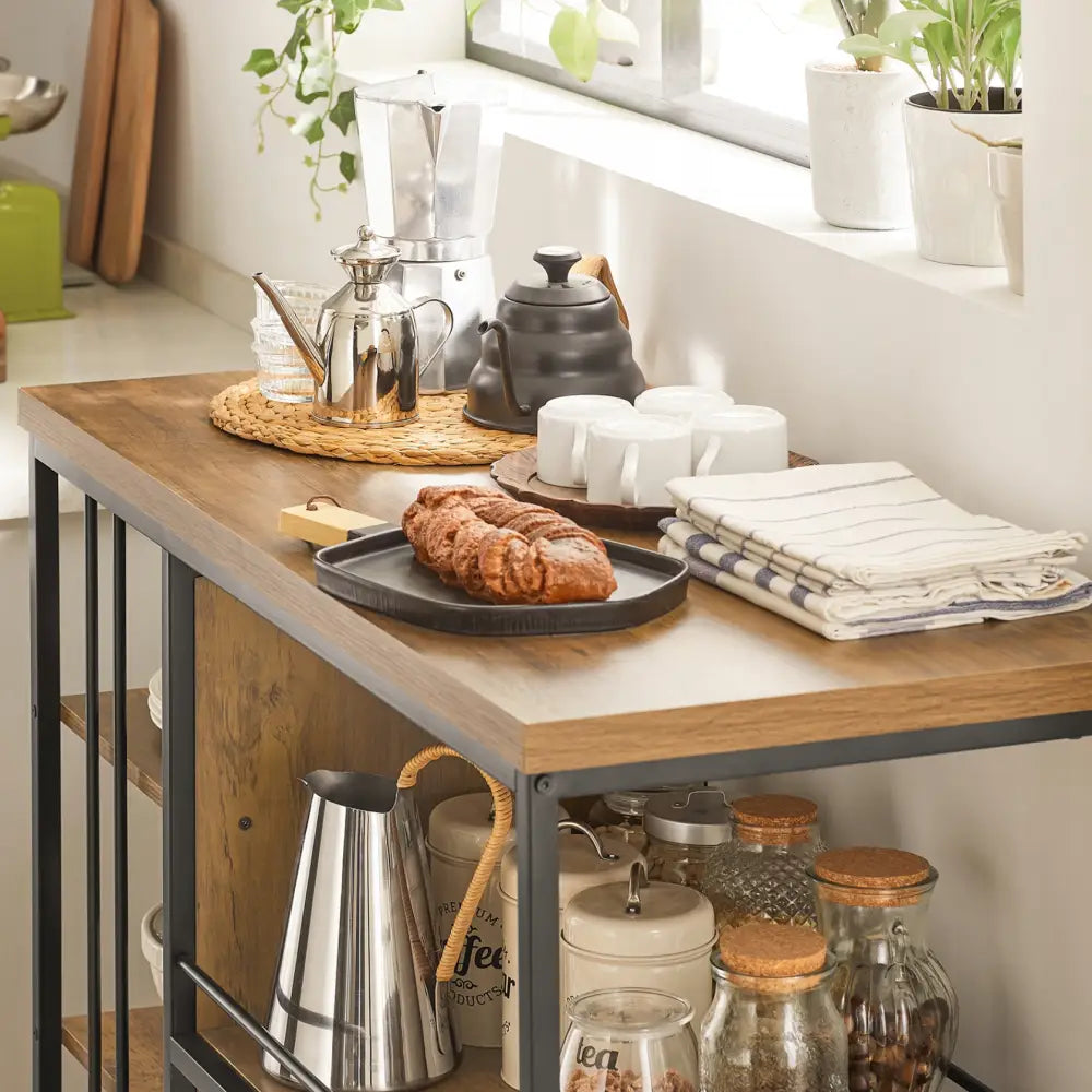 Kjøkkentrolley med treplate og metallramme, avbildet fra siden med serveringsbrett, bakverk og kaffeutstyr.