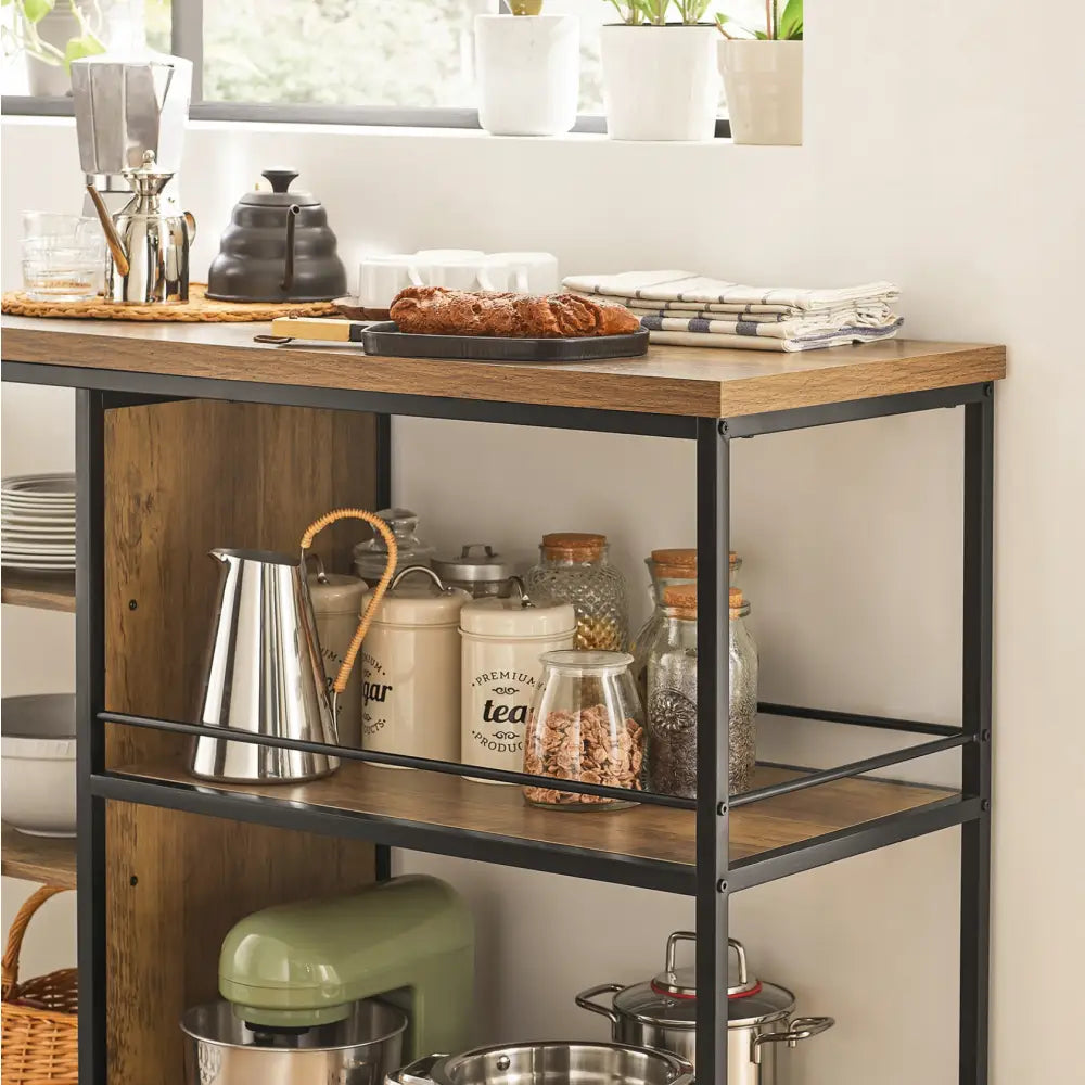 Kjøkkentrolley i sort metall og tre, skråvisning med glasskrukker, keramikkbokser og kjøkkenmaskin på hyllene.